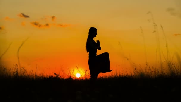 Silhouette eines jungen Mädchens beim Yoga bei Sonnenuntergang — Stockvideo