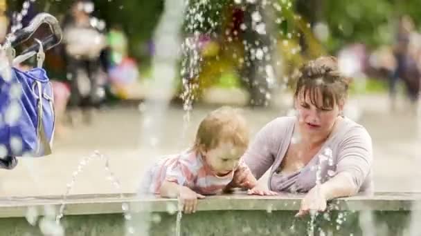 Mor och barn njuter av fontäner i parken — Stockvideo