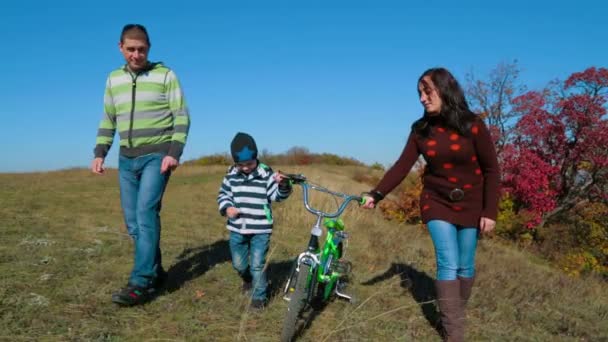 Familia feliz teniendo un paseo en el prado de otoño — Vídeos de Stock
