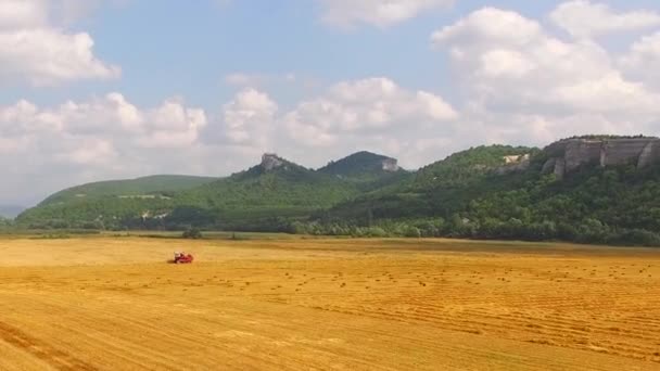 Cosechadora de granos trabajando en el campo de Goldin en un hermoso terreno montañoso — Vídeos de Stock