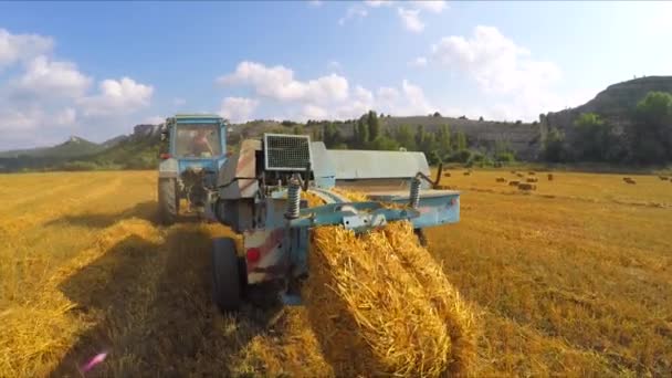 Трактор для изготовления тюков сена — стоковое видео