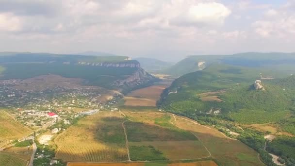 Panorama aéreo da localidade montanhosa e campos de colheita — Vídeo de Stock