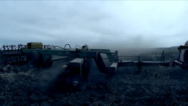 Трактор вспахивает сельскохозяйственное поле в сумерках — стоковое видео