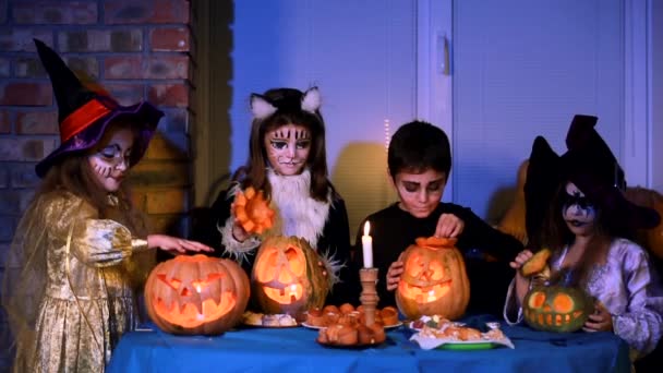 Niños con disfraces de Halloween jugando con calabazas — Vídeos de Stock