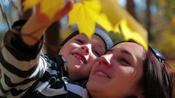 Família feliz jogando com folhas amarelas — Vídeo de Stock