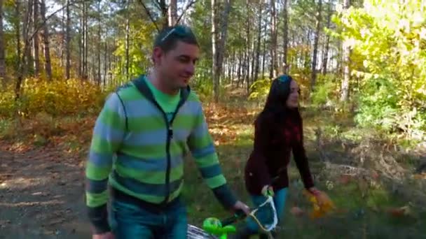 Glad ung familj promenader i höst skog — Stockvideo