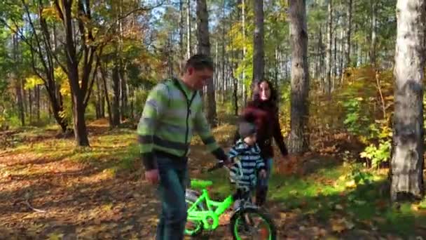 Счастливая семейная прогулка в осеннем парке — стоковое видео