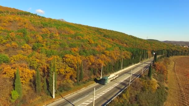 VUE AÉRIENNE. Camion roulant le long de la route près de la forêt d'automne 