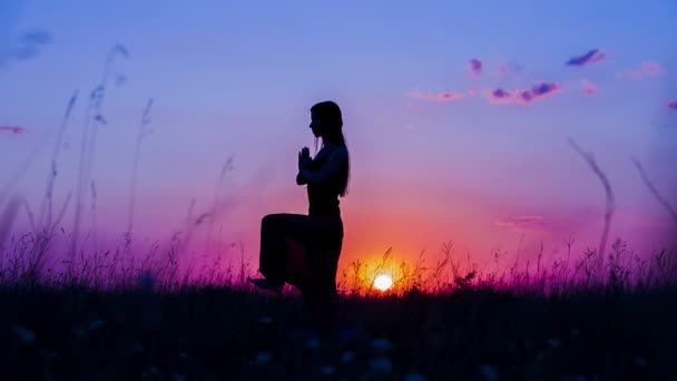 Jeune femme faisant du yoga au coucher du soleil — Video