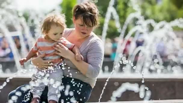 Madre y bebé jugando con fuentes en el parque — Vídeos de Stock