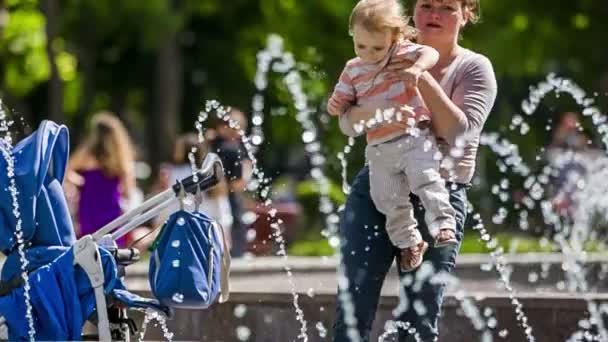 Mère met bébé dans la poussette dans le parc — Video