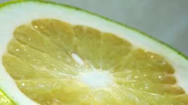 4K organik greyfurt dilimi. Bu stok video bir greyfurt dilimi yakın çekim içerir, yavaş yavaş bir daire etrafında döner.