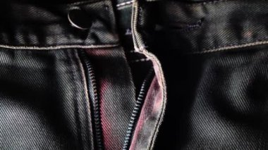 Kotun 4K metal fermuarı yakın plan. Mavi kot kumaş. Makro çekim