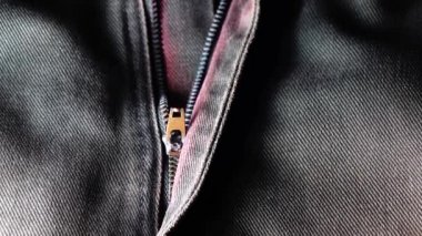 Kotun 4K metal fermuarı yakın plan. Mavi kot kumaş. Makro çekim