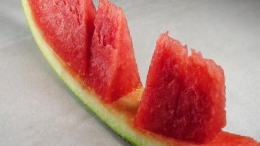 4K organik kırmızı karpuz ve granitte izole edilmiş dilimler.