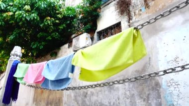 4K Çamaşır Hattı. Duvarda giysiler var.