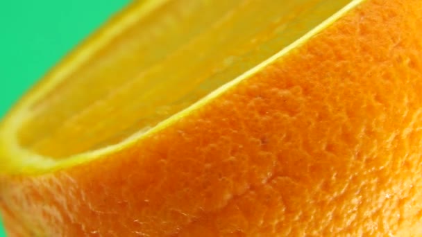 4Kネーブルオレンジの果実と回転のマクロショット 緑の背景に隔離された新鮮な柑橘類のオレンジを閉じます — ストック動画