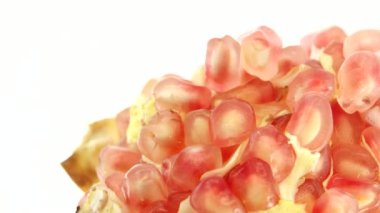 4K Organik sağlıklı kırmızı meyve yakın plan. Açık nar meyvesi beyaz arka planda döner. Nar tohumları.