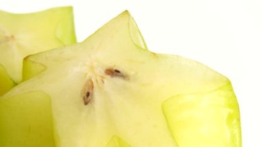 4K Organik yıldız meyve carambola veya yıldız elması (yıldız meyvesi) yakın plan beyaz zemin üzerinde döner