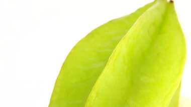 4K Organik yıldız meyve carambola veya yıldız elması (yıldız meyvesi) yakın plan beyaz zemin üzerinde döner
