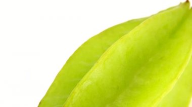 4K Organik yıldız meyve carambola veya yıldız elması (yıldız meyvesi) yakın plan beyaz zemin üzerinde döner