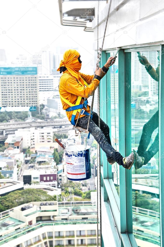 Painters high building condo outdoors sprinkle with rope safe sure in bangkok thailand.