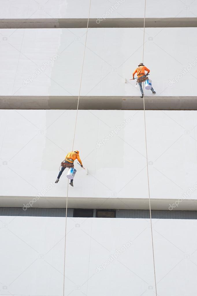 Painters high building condo outdoors sprinkle with rope safe sure in bangkok thailand.