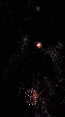 4 bin. Gerçek havai fişeklerin kusursuz döngü arka planında gece gökyüzünde Bokeh ışıkları olan altın havai fişekler. Parlak havai fişek gösterisi. Yeni yıl arifesinde havai fişekler birden fazla rengi kutluyor.