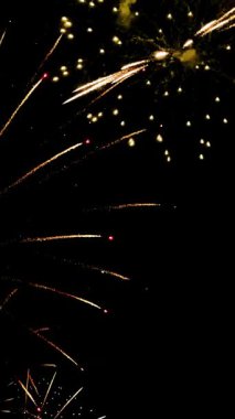 4 bin. Gerçek havai fişeklerin kusursuz döngü arka planında gece gökyüzünde Bokeh ışıkları olan altın havai fişekler. Parlak havai fişek gösterisi. Yeni yıl arifesinde havai fişekler birden fazla rengi kutluyor.