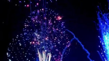 4 bin. Gerçek havai fişeklerin kusursuz döngü arka planında gece gökyüzünde Bokeh ışıkları olan altın havai fişekler. Parlak havai fişek gösterisi. Yeni yıl arifesinde havai fişekler birden fazla rengi kutluyor.