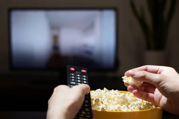 Ręka Mężczyzny Chwytająca Popcorn Żółtej Miski Podczas Zmiany Kanałów Telewizyjnych — Zdjęcie stockowe