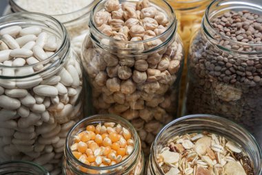 Bir masaya çeşitli malzemeler konulmuş cam kavanozlar. Sıfır atık.