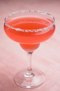 Pembe arka planda kırmızı Margarita kokteyli.