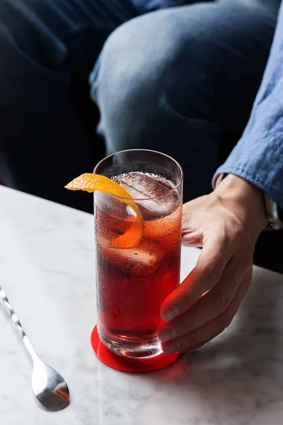 Mão Homem Agarra Cocktail Americano Com Torção Laranja — Fotografia de Stock