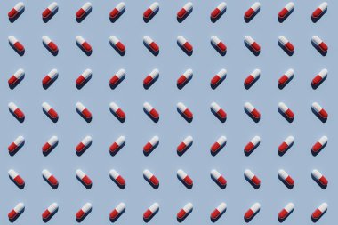 Mavi arka planda kırmızı ve beyaz kapsüller. 3B görüntüleme