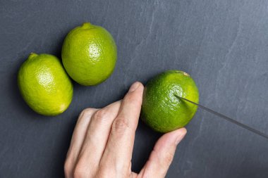 Bir adam bıçakla limon kesiyor.