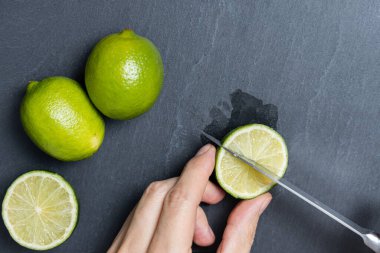 Bir adam bıçakla limon kesiyor.