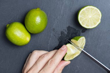 Bir adam bıçakla limon kesiyor.