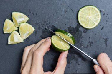 Bir adam bıçakla limon kesiyor.