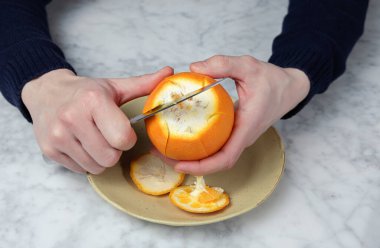 Adamın elleri bıçakla portakalı soyuyordu. Sağlıklı gıda konsepti