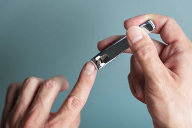 Tırnak makası kullanan bir adam. Manikür