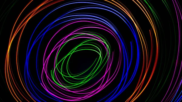 Multi color light painting photography, swirl and curve of blue, green and red light against a black background