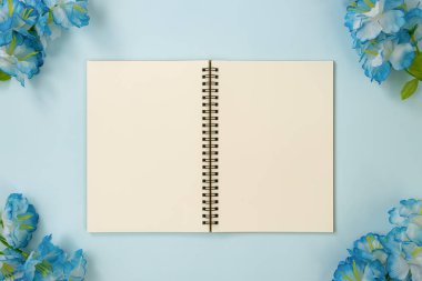 Mavi Pastel Minimalist Arkaplanındaki Köşedeki Orta Çerçeve ve Mavi Çiçekler Üzerine Çizgisiz Not Defteri