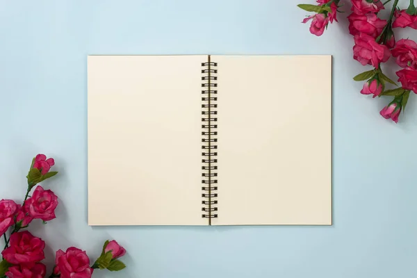 Üst Tablo Spiral Not Defteri veya Mavi Pastel Minimalist Arkaplanda Alt Sol ve Üst Sağ Köşedeki Çizgisiz Çerçeve ve Gül Çiçekleri Üzerine Çizgisiz Not Defteri