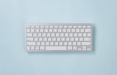 Orta Çerçevedeki Mavi Pastel Minimalist Arkaplanda Geniş Açı Beyaz Taşınabilir Bilgisayar Anahtarları veya Klavye Düğmesi