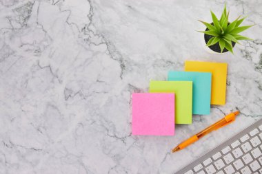 Modern Temiz Mermer Ofis Masasına veya Ofis Masasına Dört Renkli Not veya Not Defteri ve Bilgisayar Klavyesi ve Ofis Bitkisi ve Kalem