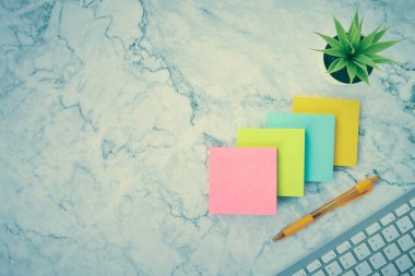 Dört Renkli Not veya Not Defteri ve Bilgisayar Klavyesi ve Modern Temiz Mermer Ofis Masası üzerine Ofis Bitkisi ve Kalemi