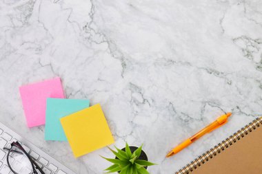 Modern Clean Flat Lay veya Üst Görünüm Ofis Masası veya Ofis Malzemeleri Not Defteri veya Not Defteri, Bilgisayar Klavyesi, Kalem, Spiral Not Defteri, Ofis Bitkileri, Mermer Minimalist Arkaplan Gözlüğü