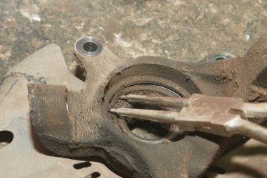 Araç Tamircisi veya Tamirci Tekerlek Taşıyıcı Kilidi Halkasını Çıkarmak İçin Büyük Kilit Çemberi Kullanıyor