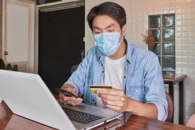 Zoom View Front, Asyalı sıradan iş adamını Denim 'de ya da Kot Gömlekli Smartphone' u Kafede Çevrimiçi Ödeme için kullandı. Covid 19 'daki Teknoloji Gelişigüzel İşadamı